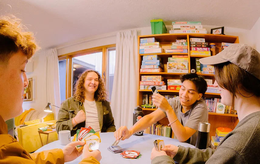 Friends playing cards in a game room.