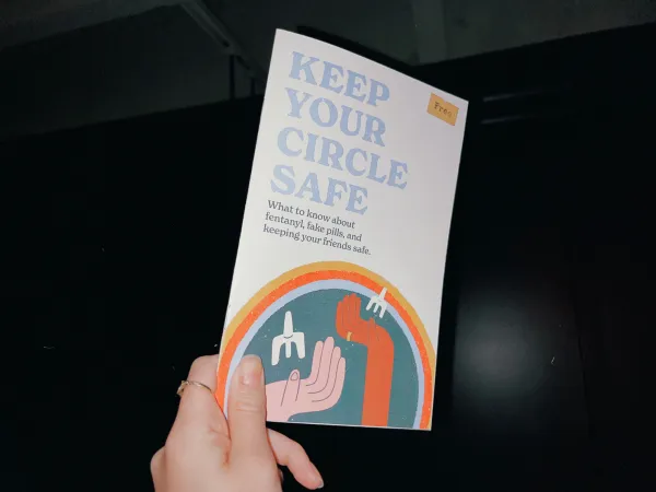 Image of a person's hand holding a booklet with the text Keep Your Circle Safe