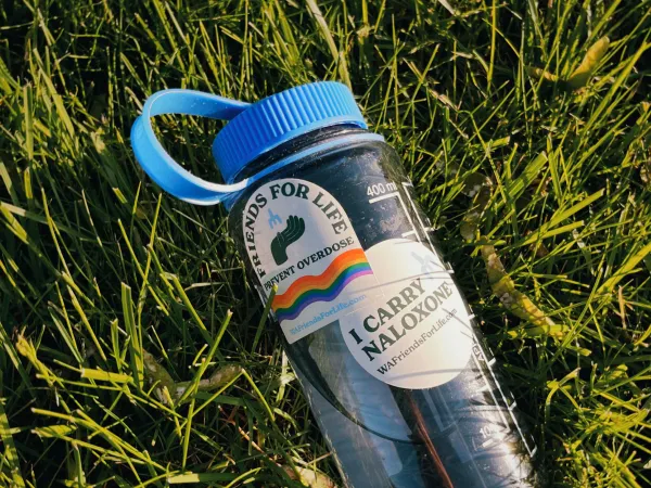 Image of a water bottle with a blue lid and Friends for Life stickers on it